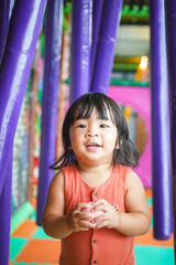 Action of a cute baby girl is playing at children playground place in happiness moment. People portrait photo with recreation activity.