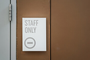 Staff only restricted area sign on the wall in grayscale tone. Sign and symbol for industrial working place object photo, selective focus.