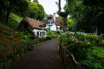 Morning atmosphere by the typical houses in Queimadas Forest Park in Santana, Madeira, starting point to the Caldeirao Verde levada trail. - 645602523