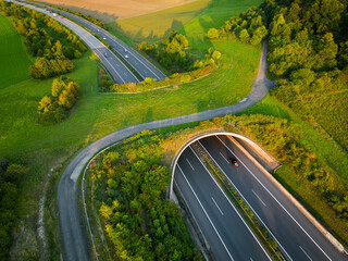 Aerial view of a green overpass over almost empty highway.