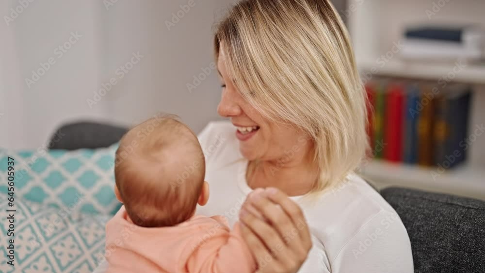 Poster Mother and daughter sitting on sofa together at home