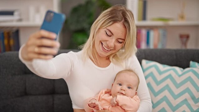 Mother and daughter hugging each other make selfie by smartphone at home