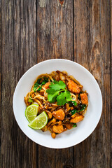 Asian food - chicken nuggets, noodles and fried shimeji mushrooms on wooden table
