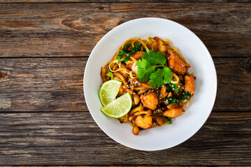 Asian food - chicken nuggets, noodles and fried shimeji mushrooms on wooden table
