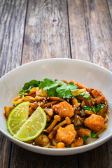 Asian food - chicken nuggets, noodles and fried shimeji mushrooms on wooden table
