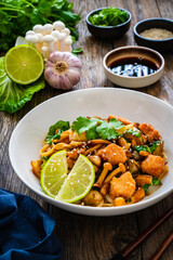 Asian food - chicken nuggets, noodles and fried shimeji mushrooms on wooden table

