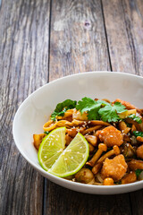 Asian food - chicken nuggets, noodles and fried shimeji mushrooms on wooden table
