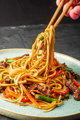 fried wok beef noodles on a black rustic background