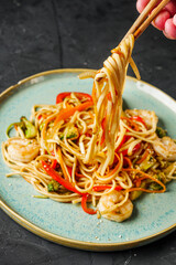 fried wok shrimp noodles on a black rustic background