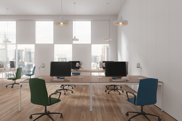 White office interior with pc monitors and desk near panoramic window