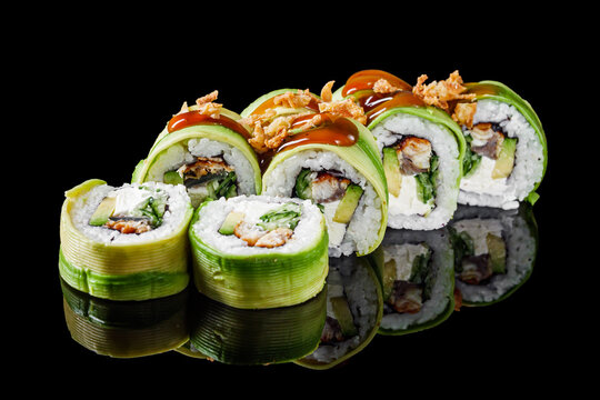 sushi roll green dragon with eel avocado cucumber cream cheese on a black mirror background