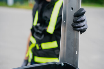 Construction worker holding metal bar with rubber gloves on close up