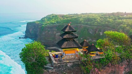 Bali's Most Iconic Landmark and popular tourist attraction Uluwatu Temple one of six key Balinese hindu temple perched on top mountain cliff on background amazing nature Bali, Indonesia. 4K Aerial