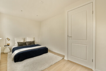 a bedroom with white walls and hardwood flooring the room has a bed, two nightstands and a window