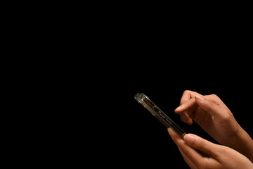 Woman hand holding smartphone isolated on black background with copy space for advertise text