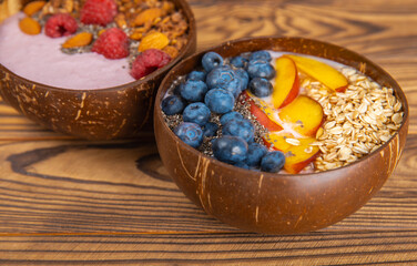 Bowl of granola with yogurt and fresh berries on a texture table. Yogurt berries, acai bowl, spirulina bowl. Healthy food, balanced breakfast. Strawberries, blueberries, kiwi, peach, almonds and chia.