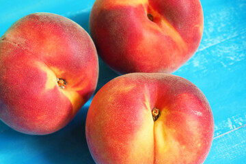 Ripe peaches in the bright sun on a blue background