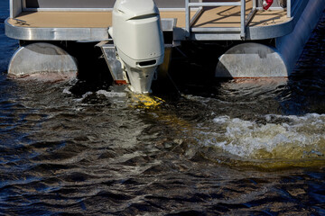 A running outboard motor on a boat in the water.