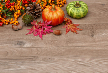  Herbstdekoration aus Kürbissen, Beeren und Blättern auf Holzhintergrund. Konzept des Erntedankfestes oder Halloweens. Herbstkomposition mit Kopierraum.