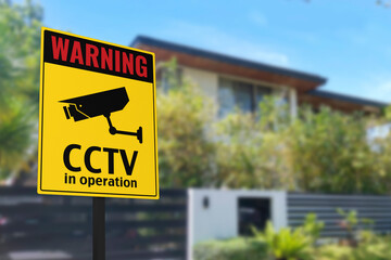 A CCTV sign in front of a gated home. Warning to visitors or burglars. Security system and...