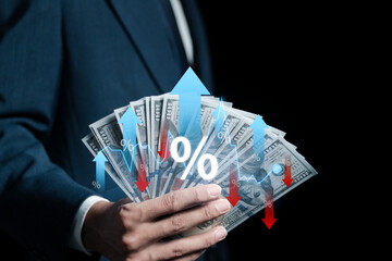 Businessman holding money with percentage icon and up and down arrow icon with graph indicator,...