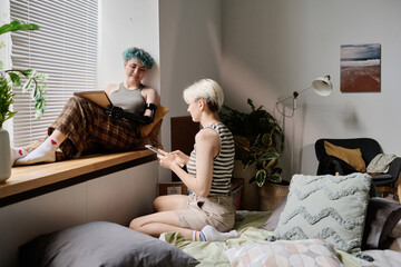 Lesbian couple spending free time at home, they drawing and using tablet pc