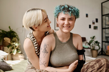 Happy lesbian girls embracing while spending time in the room
