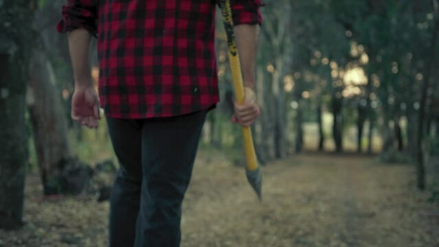 Killer man walks with axe in hand in the forest