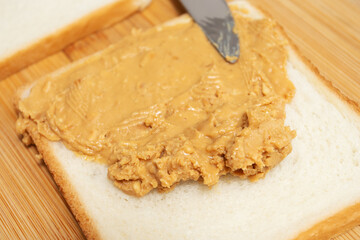 classic american sandwich, spreading peanut butter on bread, close-up