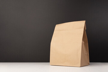 School lunch bag with brown paper packaging, Eco-friendly package for kids on the background of the blackboard