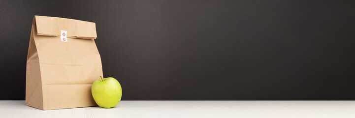Lunch bag for school banner, Eco-friendly package for kids and an apple on the background of the blackboard