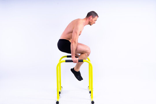 Strong man doing sports. Fitness on gorizontal and parallel bars. Pull ups on parallel bars.
