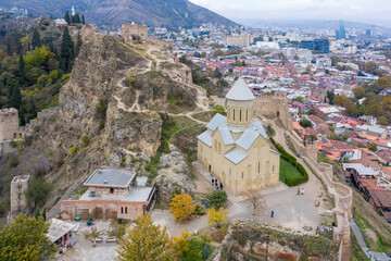 Fototapeta na wymiar Birds eye view of Narikala Fortress and Saint Nicholas's Church on cloudy autumn day. Tbilisi, Georgia.