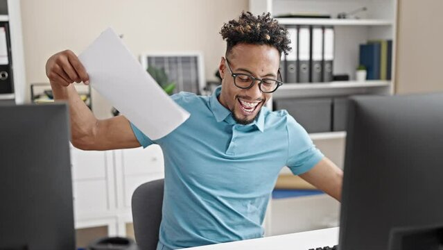 African american man business worker using computer throwing documents dancing at office