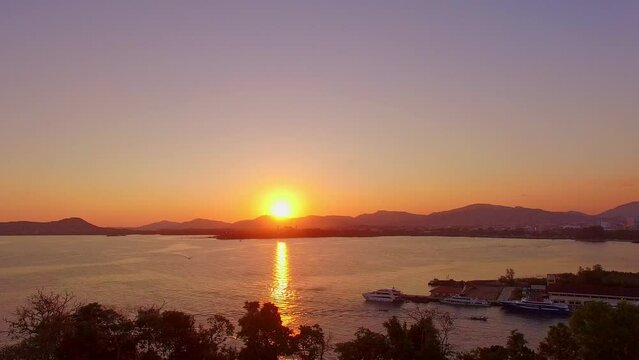 .aerial panorama view beautiful yellow sunset above the sea..Looping video features a beautiful scene with the setting sun painting the sky above mountain range..stunning red sky background.