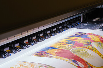 Industrial printing on woven material; modern digital inkjet printer puts a blue pattern picture on...
