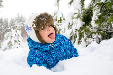 Child play in the snowy forest in winter