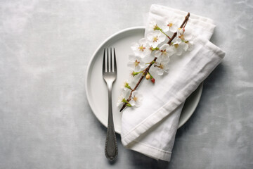 Spring table setting with cherry blossom twigs and napkin on light background