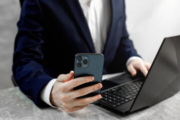 A businessman looking at a smartphone and working on a laptop 8