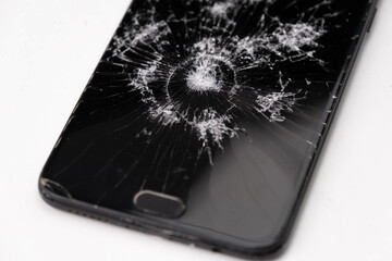 Broken black touch screen phone isolated on a white background. Broken glass with cracks from...
