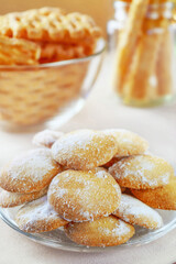 Cookies on a plate. Selective focus. Photo of a delicious dessert with powdered sugar, food. Sweets in the background in blur.
