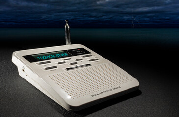 Tropical storm warning on a weather radio with ocean and storm