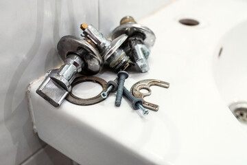 faulty ball valves and fixtures lie on edge of sink close up after removing the faucet