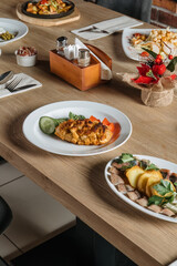 The food table is set with lunch dishes. Simple food, potatoes, cucumbers, meat. Vertical photo.