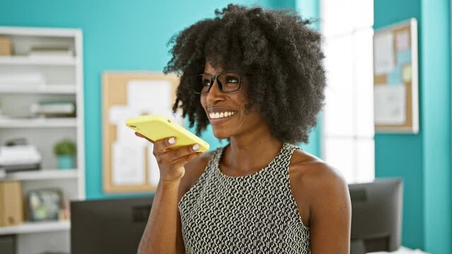 African american woman business worker sending voice message by smartphone working at the office