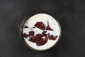 Beef liver soaked in milk in a black bow. Fresh liver in milk before cooking