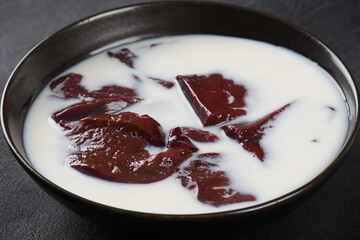 Beef liver soaked in milk in a black bow. Fresh liver in milk before cooking