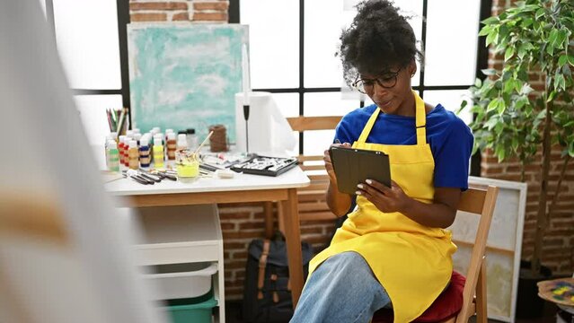 African american woman artist drawing on touchpad smiling at art studio