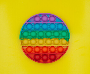 Multi-colored popular silicone anti-stress toy pop it on a yellow background 