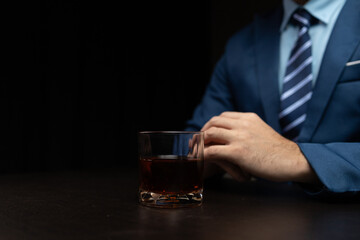 Man with glass of whiskey, businessman drinking whiskey in dark room, drinking alcohol drunk, businessman stress. Intoxicated drink concept.